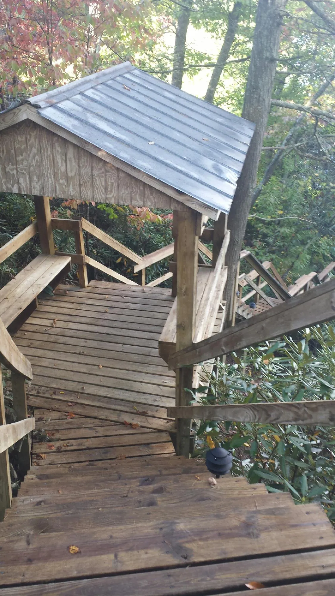 Metal roofed shelter over wooden steps on a wooded walkway — Skylight Repair & Installation work by our crew in Vienna